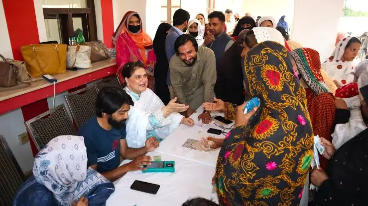 BISP Payments Shift to Shops from June 2025 – How to Collect 13,500 PKR Easily A Pakistani woman receiving her BISP 13,500 rupees payment from a shop agent through biometric verification in June 2025.